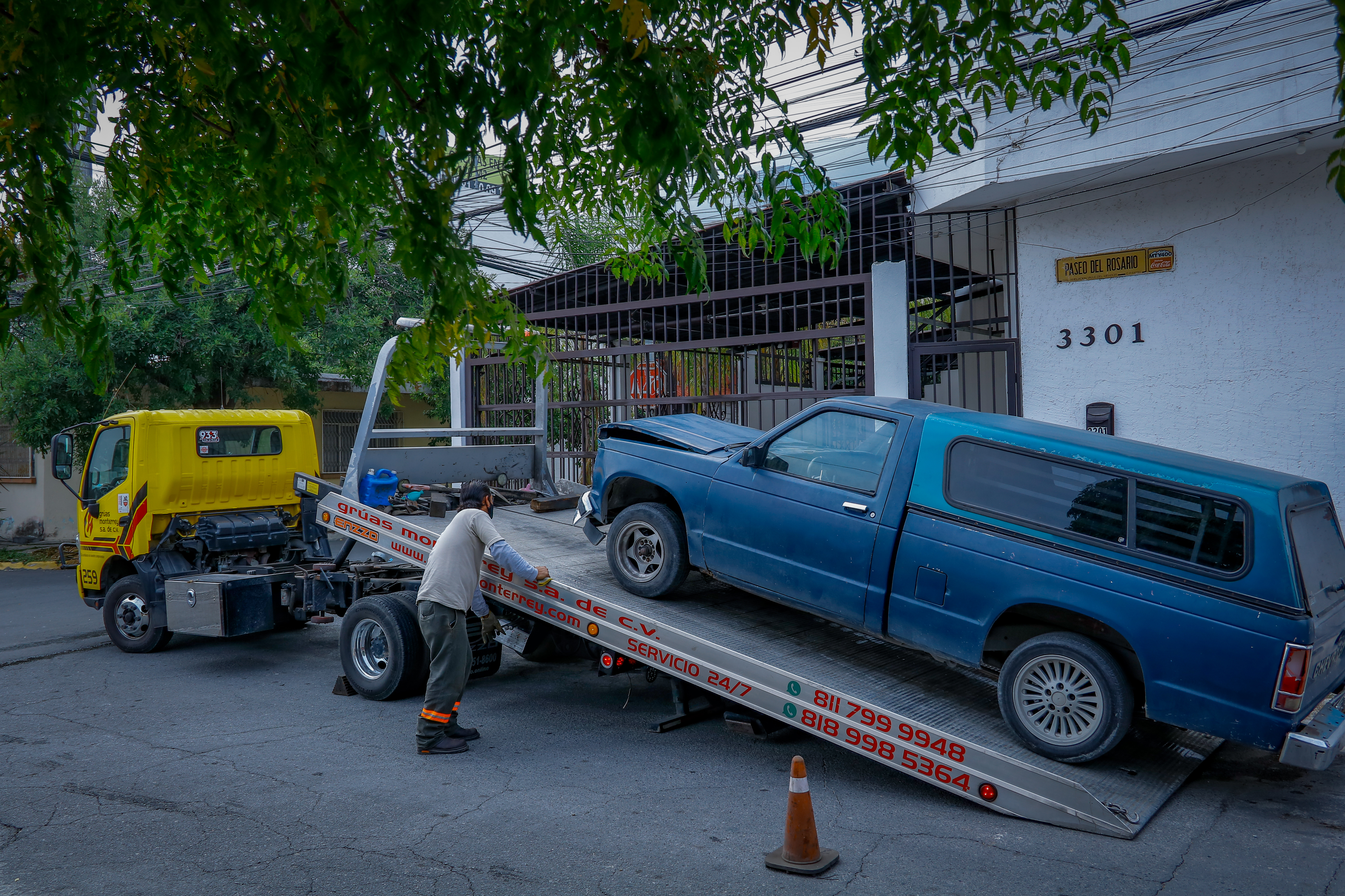 Grúa de plataforma tipo A de Grúas Monterrey con un sedán asegurado en la cama.